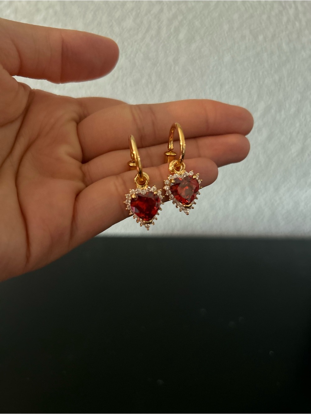 Gold earring with red heart gems